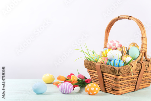 Happy easter, Easter painted eggs in the basket on wooden rustic table for your decoration in holiday. copy space.