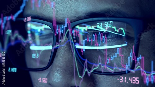 Close-up camera to trader's glasses analyzing stock charts