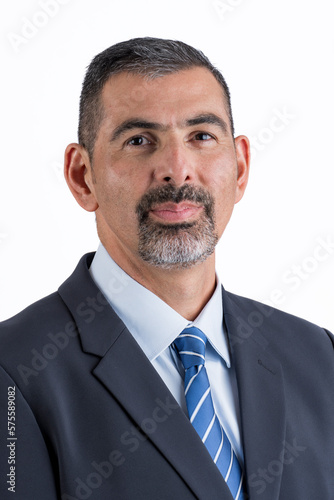 Close-up portrait of a bearded man in a suit looking at the camera on a white background.