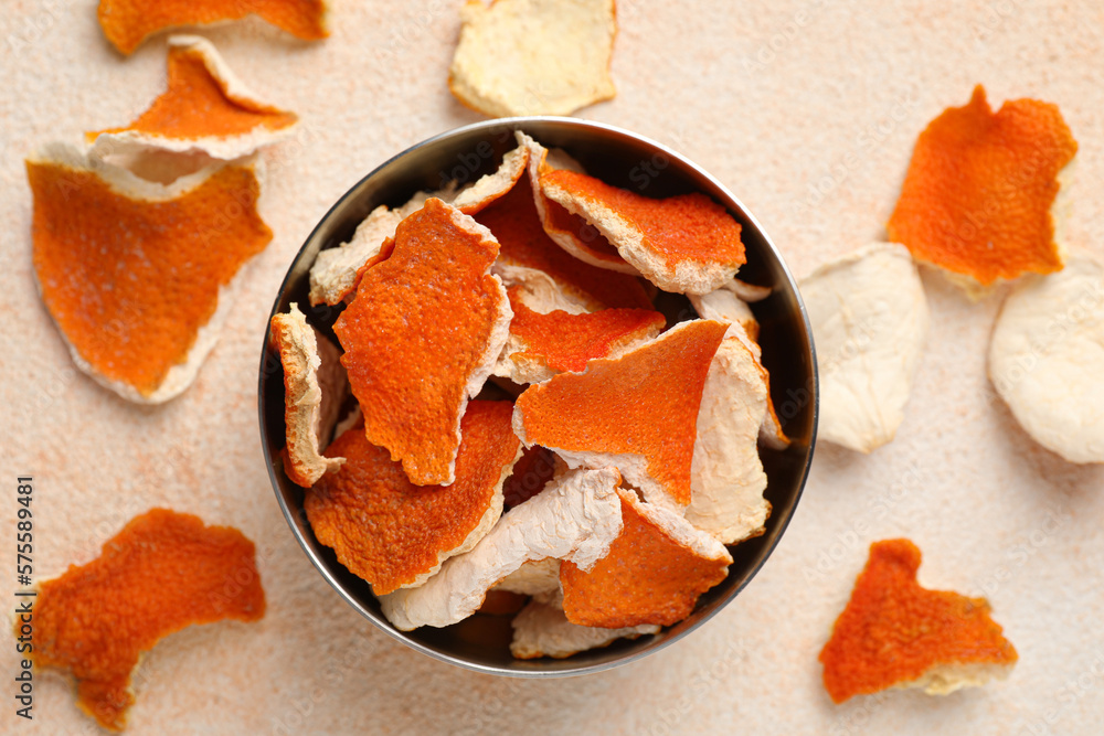 Dry orange peels with bowl on beige table, flat lay Dry orange peels with bowl on beige table, flat lay