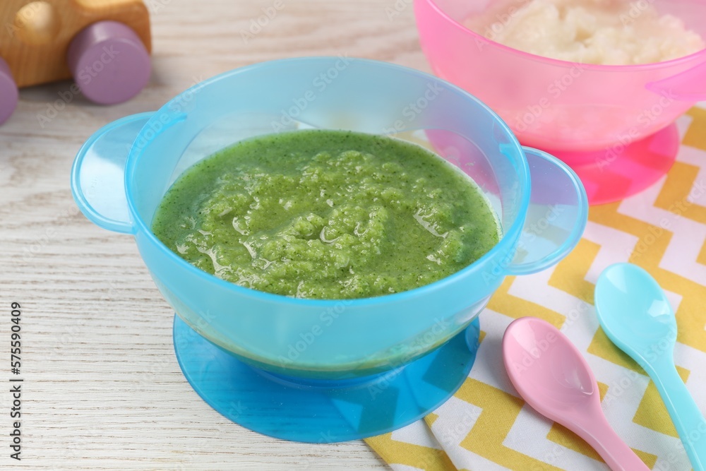 Healthy baby food. Different tasty puree in bowls on white wooden table Healthy baby food. Different tasty puree in bowls on white wooden table