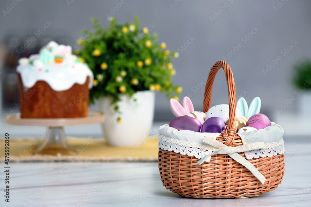 Easter basket with painted eggs and decorations on white marble table. Space for text