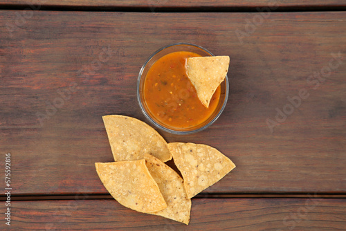 Tasty salsa sauce and Mexican nacho chips on wooden table  flat lay