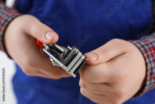 Professional electrician stripping wiring on white background, closeup