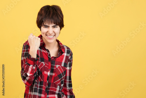 Androgynous person celebrating while raising one fist
