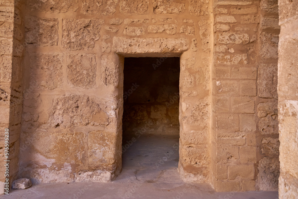 Doorway in an ancient wall of roughly hewn stone, leading into a dark empty room