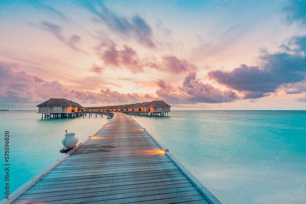 Amazing beach landscape. Beautiful Maldives sunset seascape view. Horizon colorful sea sky clouds, over water villa pier pathway. Tranquil island lagoon, tourism travel background. Exotic vacation
