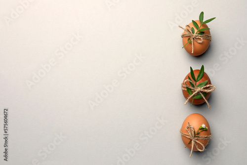 Festively decorated chicken eggs on light grey background  flat lay with space for text. Happy Easter