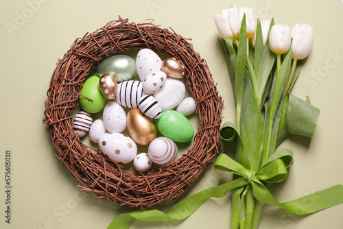Flat lay composition of painted Easter eggs and tulip flowers on light green background #575605038