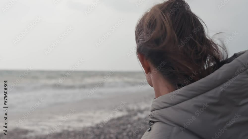 Young woman wearing a warm clothes on the beach in Turkey during a storm Young woman wearing a warm clothes on the beach in Turkey during a storm