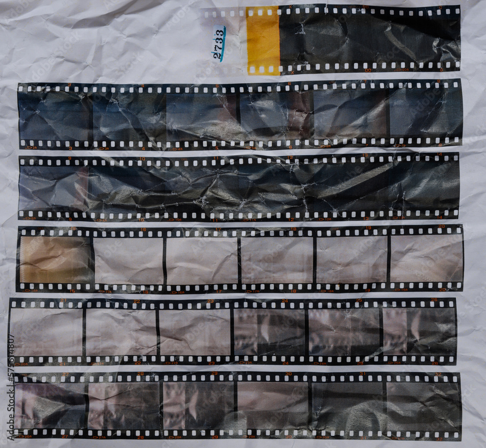 set of retro long 35mm positive strips printed on white crumpled paper, contact sheet with empty frames or film cells. cool cover or poster idea.
