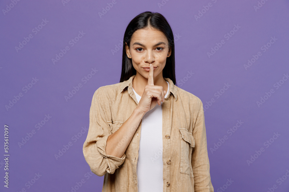 Young secret latin woman wearing light shirt casual clothes saying hush be quiet with finger on lips shhh gesture isolated on plain pastel purple color background studio portrait. Lifestyle concept. Young secret latin woman wearing light shirt casual clothes saying hush be quiet with finger on lips shhh gesture isolated on plain pastel purple color background studio portrait. Lifestyle concept.