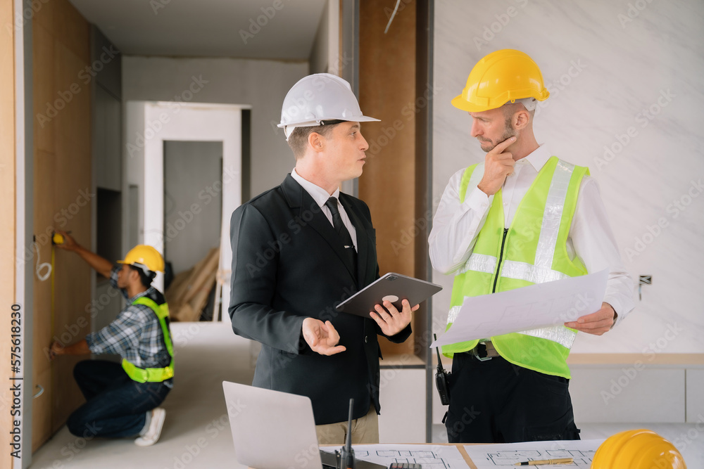 Businessman working as a team discussing data working and tablet, laptop with on on architectural project at construction site at desk. Businessman working as a team discussing data working and tablet, laptop with on on architectural project at construction site at desk.