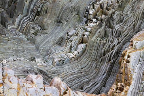 Geological fold with Wavy layers of limestone and quartzite rocks on a cliff photo