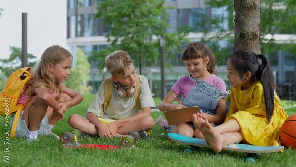 Happy kids playing and talking together in city park, during summer day. Happy kids playing and talking together in city park, during summer day.