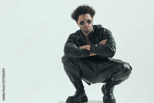 casual man squatting on the chair and crossing his arms