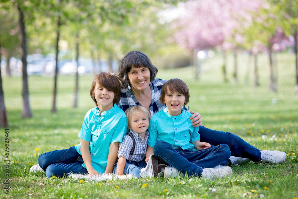 Cute children in the park with grandmother, springtime Cute children in the park with grandmother, springtime
