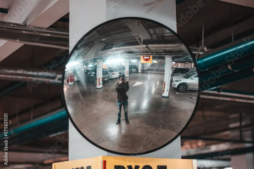 A person photographs himself through a reflective surface. Shot through a mirror. The photographer takes a selfie.