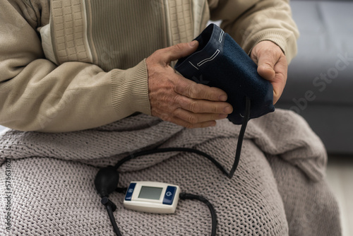 Senior man using medical device to measure blood pressure