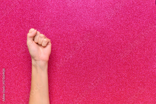woman's fist on pink bright background