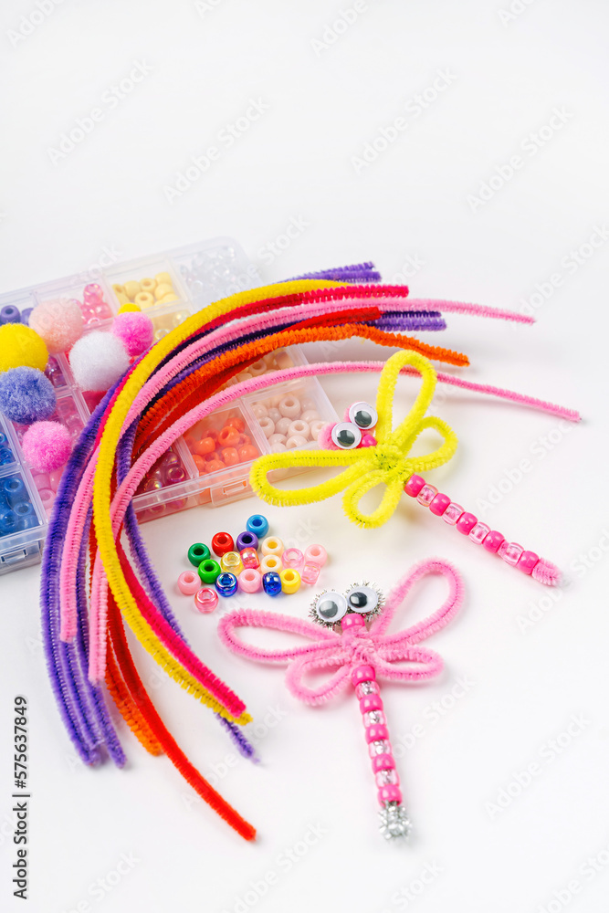 Fototapeta premium Beaded Pipe Cleaner dragonflies. Easy kids crafts. Different multi-colored supplies and materials for DIY art activity for kids. Children's crafts, creativity and hobby.