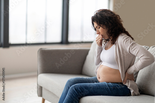 Morning Sickness. Pregnant Woman Suffering Nausea While Sitting On Couch At Home