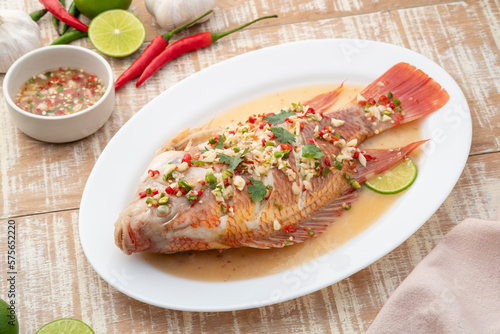 Steamed Red Tilapia Fish In Spicy Lime Soup on white plate