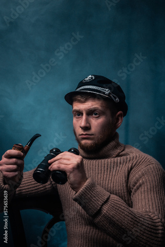 Vessel captain. A man in a sweater and cap. Smokes a pipe. Male profession.