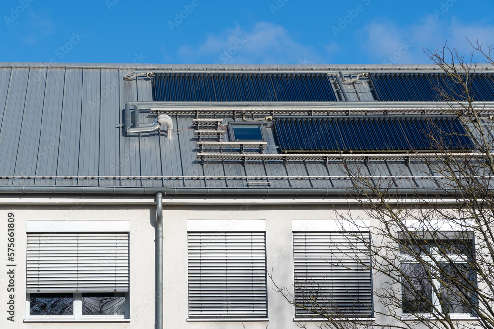 solar thermal system on a roof of a building, blue sky solar thermal system on a roof of a building, blue sky