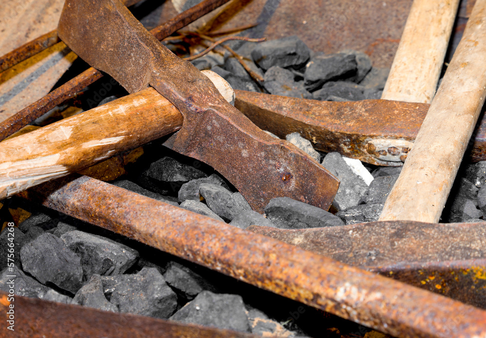 hammer and other old tools over the pieces of coal in an artisanal factory where iron is worked hammer and other old tools over the pieces of coal in an artisanal factory where iron is worked