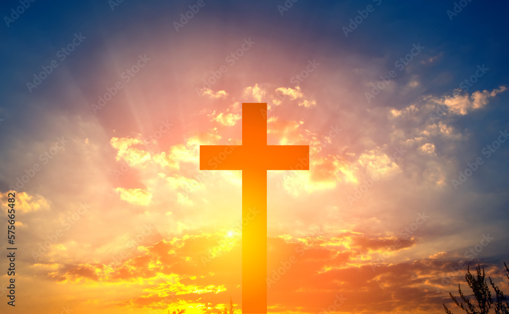 Cross in the rays of the sun against a blue cloudy sky. Banner for text about religion. Cross in the rays of the sun against a blue cloudy sky. Banner for text about religion.