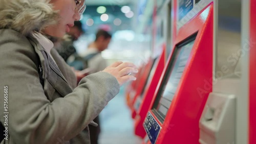 backpack happiness young asian woman travelling by train and doing transportation ticket booking using a machine. Self service kiosk and at airport subway for check in. selective focus