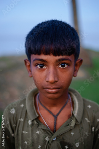 portrait of a South asian poor rural teenage boy wearing t shirt 