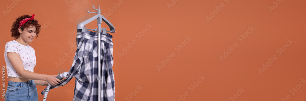 Panoramic view of the photo. A woman with a smile on her face irons a man's shirt with a steamer.