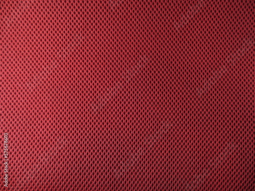 Red breathable porous poriferous material for air ventilation with holes. Sportswear material nylon texture