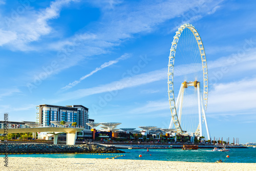 Dubai resort's harbor is a paradise for those who love modern architece, expensive boats, and skyscrapers set against a clear blue sky with fluffy clouds