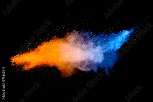 Blue orange color powder explosion cloud on black background. Closeup of Blue orange dust particles splash.