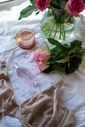 Women s bra  pink roses and perfume on a white sheet