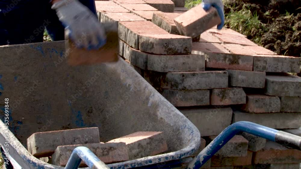 Builder loader shifts bricks blocks stacking red bricks on a pallet for further transportation to the construction site, The builder is in the process of working on the street.
Builder loader shifts bricks blocks stacking red bricks on a pallet for further transportation to the construction site, The builder is in the process of working on the street.