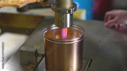 Paint cans filling by automated machinery at a factory