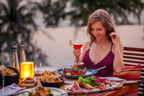 Happy young lady with a glass of cocktail in fine dining outdoor restaurant © TravelMedia