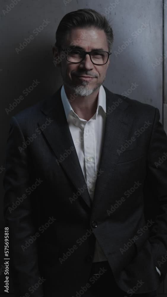 Portrait of happy mature businessman, smiling. Entrepreneur standing in front of dark loft wall. Older, middle aged, mid adult, man in his 40s or 50s in jacket, business casual. Portrait of happy mature businessman, smiling. Entrepreneur standing in front of dark loft wall. Older, middle aged, mid adult, man in his 40s or 50s in jacket, business casual.