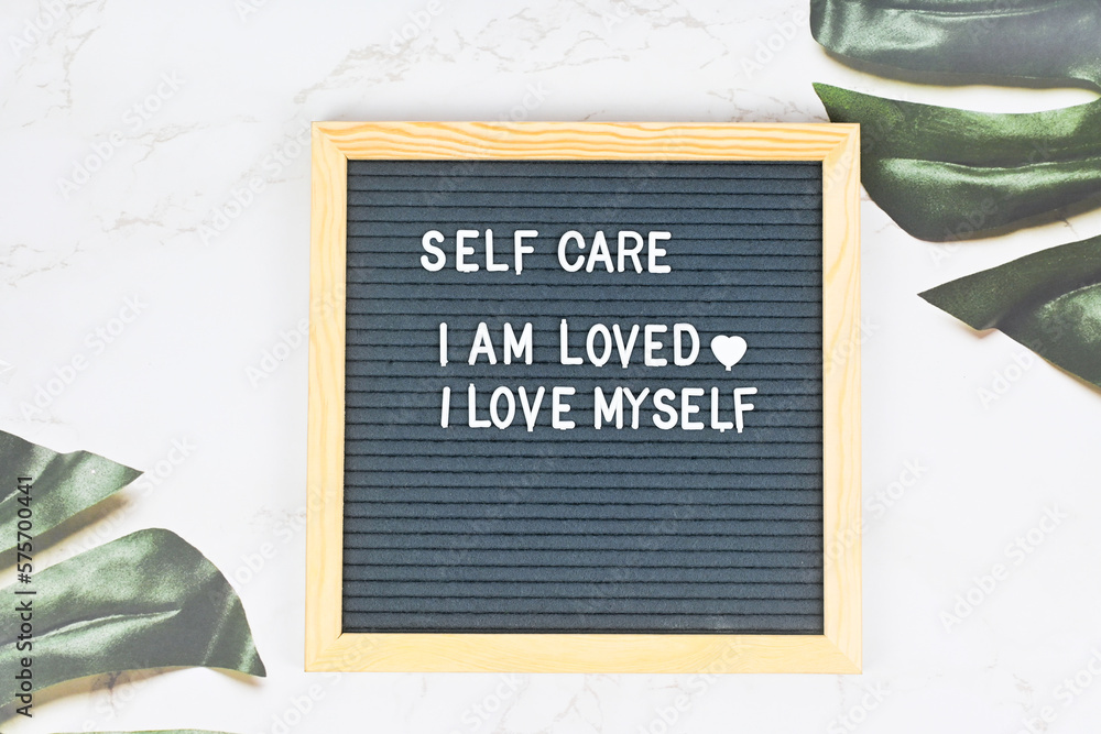 Grey letter board with phrase Self care, I am loved, I love myself