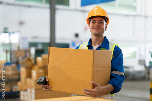 Male warehouse worker packing and carrying box of goods in the storage warehouse