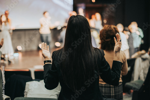 Rising in Faith: A Woman's Worshipful Gesture at Church photo