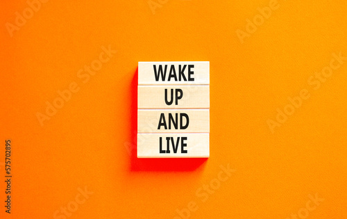 Wake up and live symbol. Concept words Wake up and live on wooden blocks. Beautiful orange table orange background. Business lifestyle wake up and live concept. Copy space.