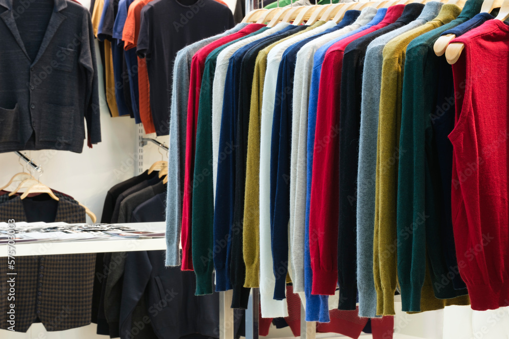 Fashion clothes on clothing rack - bright colorful closet. Closeup of rainbow color choice of trendy female wear on hangers in store closet or spring cleaning concept. Summer home wardrobe. Fashion clothes on clothing rack - bright colorful closet. Closeup of rainbow color choice of trendy female wear on hangers in store closet or spring cleaning concept. Summer home wardrobe.