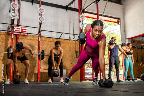 Group of people doing dumbbell push-ups
