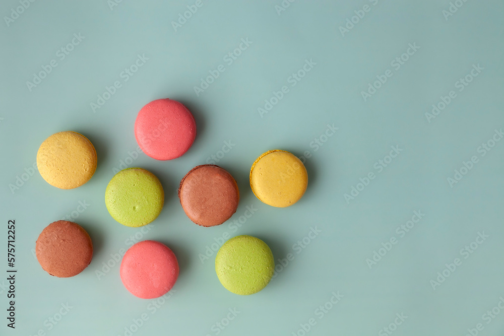 Obraz premium Multi color macaroons on turquoise background top view flat lay