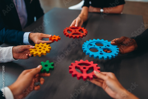 Businessteam work together and combine pieces of gears. Partnership and integration concept